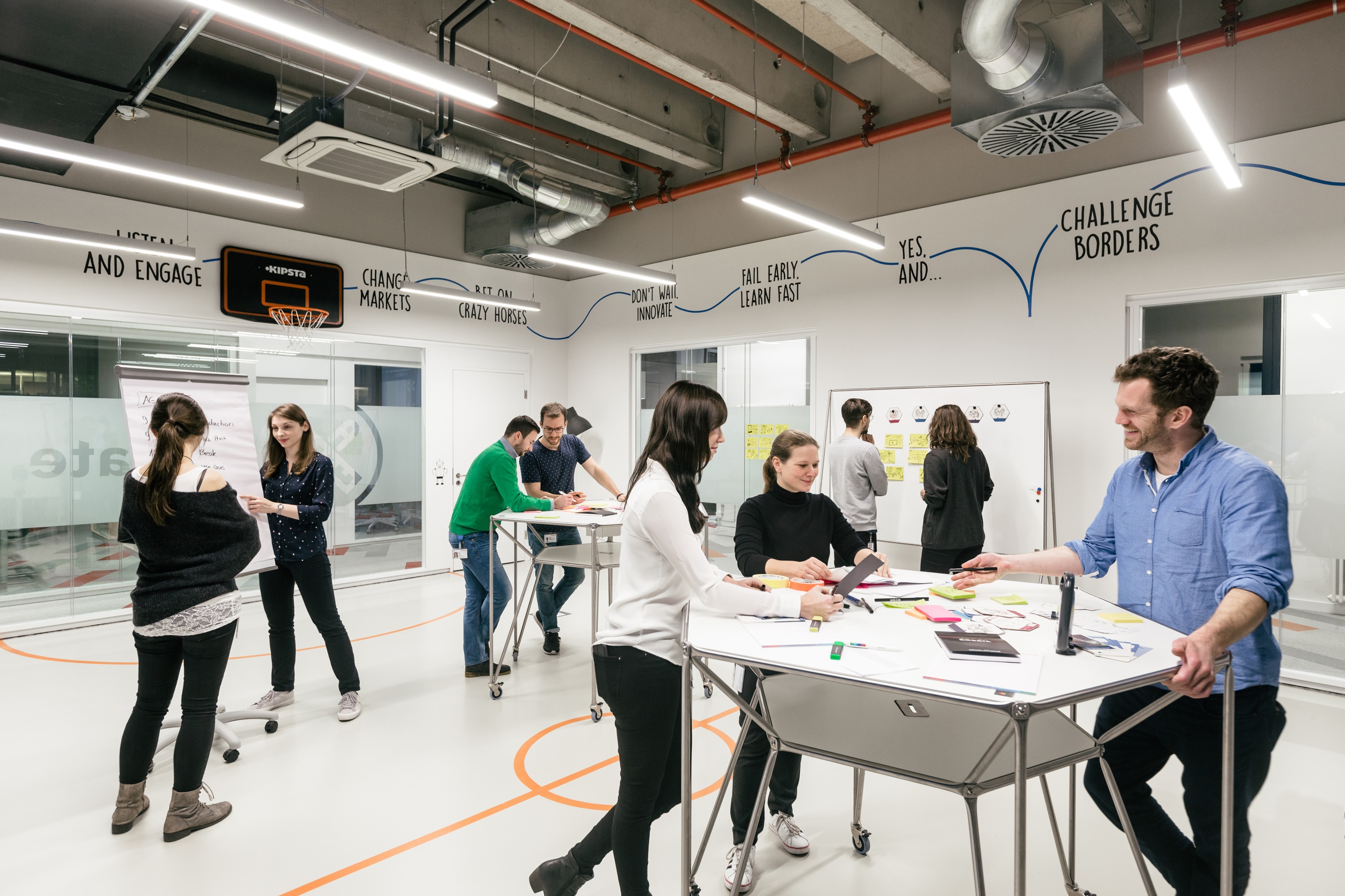 Open space office with employees discussing at their tables